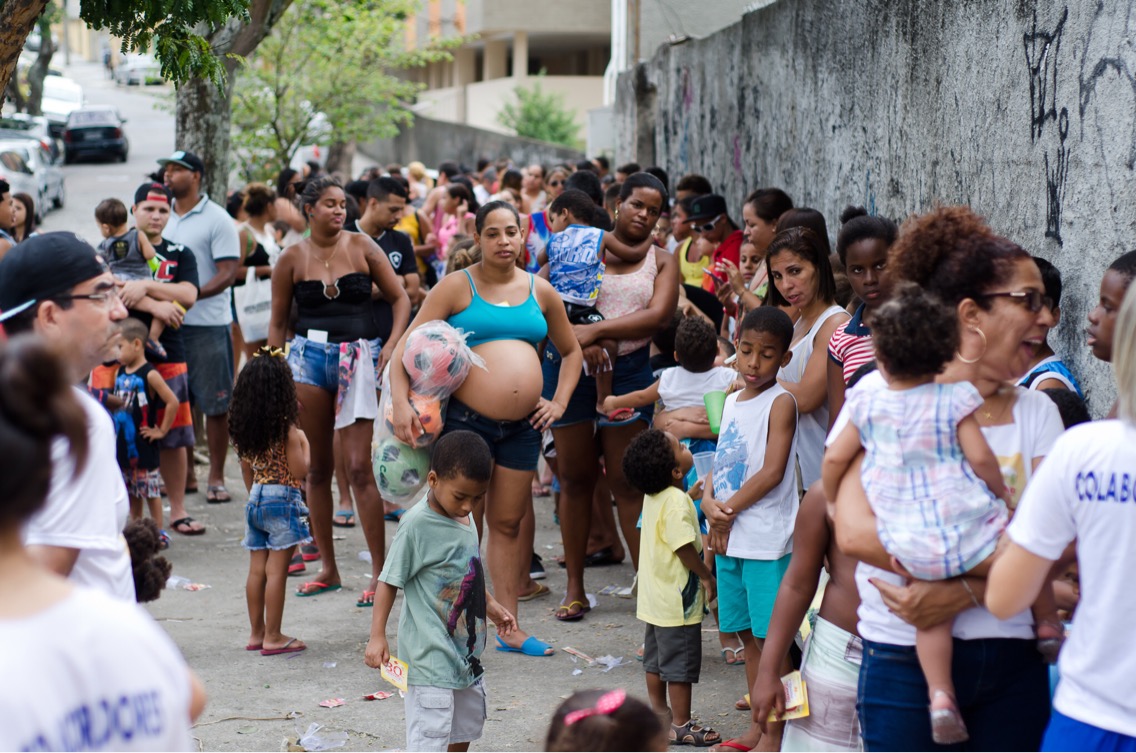 Vista aérea da festa com muitas crianças e voluntários.